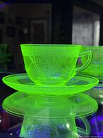 Tea cup and saucer glowing bright green under UV light