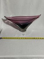 Front view of large purple Murano glass whale tail centerpiece alongside measuring tape showing width around 18 inches.