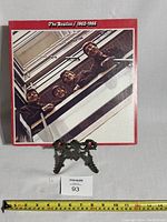 Front cover of The Beatles Red Album double vinyl LP, showing band members looking down stairwell.