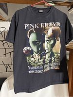 Front view of black vintage Pink Floyd T-shirt with colorful album artwork and text.