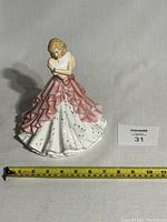 Front view of Royal Doulton Bethany HN5561 figurine 9 inches tall with measuring tape in foreground.