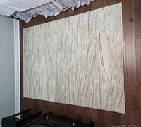 Rectangular white and sand pattern carpet laid on wooden floor, showing full carpet surface and texture.