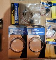 Photo showing two 12 inch blue LED strip lights on reels still in original packaging along with three inline fuse taps in sealed plastic bags.