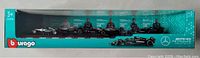 Front of turquoise-green display box showing six model cars and Burago/Mercedes-AMG Petronas branding