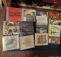 Overview of CD collection showing various music albums arranged on a flat surface including Bee Gees, Frank Sinatra, The Angry Kids, and others.