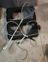 Three fishing nets on the floor, handles visible, nets in black mesh, two appear new with white labels on handles