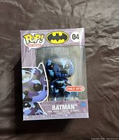 Front view of unopened Funko Pop! Batman figure box showing figure inside with blue and purple camouflage design. Target exclusive sticker visible.