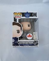 Front of unopened box containing vinyl figure of Auston Matthews in Toronto Maple Leafs uniform, number 20.