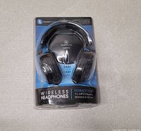 Front view of wireless headphones in blister packaging showing product and branding with minor package tears