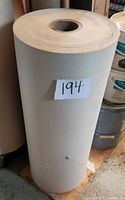 Side view of a large cylindrical roll of off-white masking paper with label '194' attached.