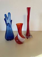 Group photo of the three glass vases on a white surface with plain background showing size and color contrast