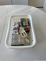 Basket containing assorted peel and stick hooks and suction cup hooks, various sizes and styles.