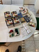 Full table view showing the assortment of various packaged light bulbs including boxes of Philips infrared heat lamps, some loose packaged bulbs, small bulbs and accessories.