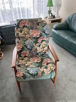 Front view of lounge chair with floral slipcover draped over seat and back