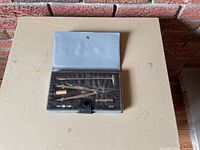 Full set of precision drawing instruments in open blue case showing all items in foam inserts.