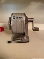 Side view showing the Vacuhold label, crank handle, and suction base