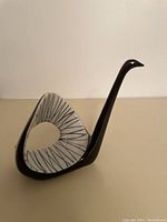 Front and side view of a fine china black and white swan statue with abstract line pattern details
