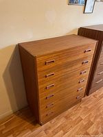 Front view of six-drawer teak chest of drawers showing integrated wood handles