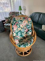 Front view of wicker swivel chair with floral cushions showing seat and backrest details.