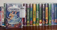 Disney VHS movies lined up showing titles and original packaging of some tapes such as Cinderella