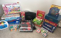 Overall arrangement of all items on carpet: board games, handheld console, tape recorder, card games