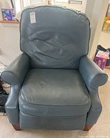 Front view of vintage reclining leather armchair showing seat, backrest, and armrests.