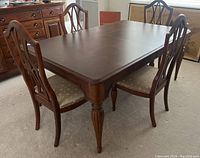Full view of dining table and 4 chairs set, showing dark wood finish and carved legs.