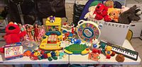 Wide view of vintage toy lot arranged on tables with various toys, dolls, and plush in bright colors