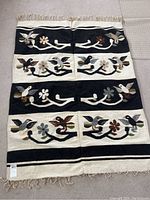 Full view of the Zapotec rug showing overall pattern and fringed ends.