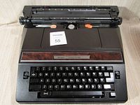 Front angled view of the black Sears Correct-O-Ball XL-1 electric typewriter with paper roller and keyboard visible.