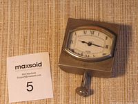 Three-quarter angled view of the clock on fabric surface with winding stem extended.