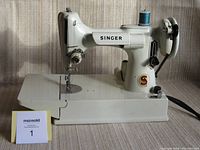 Front and left-side view of white Singer Featherweight 221K on removable base plate