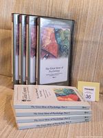 Four DVD cases standing upright with covers showing 'The Great Ideas of Psychology Part 1 to Part 4' and four course guidebooks stacked horizontally. A small tag with lot number is visible.