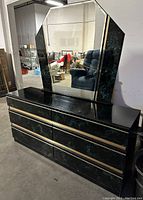 Full view of the dresser with the large beveled edge mirror showing the black and teal marble pattern with gold horizontal trim.