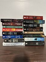 Books stacked featuring 14 Tami Hoag paperback novels with visible titles and varied colored spines