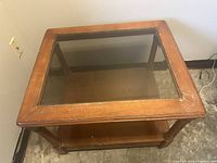 Full top view of the wooden end table showing the square glass inset and worn wooden edges.