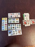 Multiple sheets and groups of vintage 1980 National Wildlife Federation conservation stamps showing diverse wildlife species in full color on a dark surface.