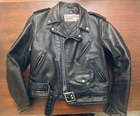 Front view showing asymmetrical zip closure, pockets, belt and epaulets