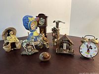 Photo showing eight decorative figurines including girl with clock, owl, seagulls, carousel horse clock, polished wood egg, and two wind-up clocks including Mickey Mouse alarm clock