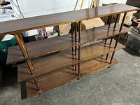 Front angled view of wooden bookcase showing four shelves, vertical supports, dark brown finish, and general condition with some wear.