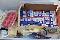 Overview photo showing a box filled with multiple blocks of blue and white packaged paraffin wax and molds in plastic bags.