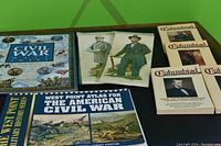 Overview photo showing several Civil War themed books, two large illustrated wall charts, and multiple packets of collectible cards