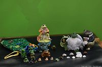 Various frog figurines with the Jeremy Fisher music box and drawstring bag visible in background