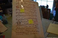 Illuminated manuscript page showing musical notation and Latin text with sticky notes annotating the contents and size.