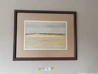 Full view of framed print showing coastal landscape with sandy beach and hills under overcast sky