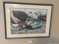 Photo of the framed print showing a realistic coastal scene with a green rowboat and oars on a rocky shore with sea in the background.