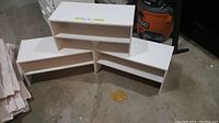 Three white 2-shelf Ikea shoe racks arranged on floor showing front and side views.