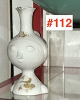 Front view of the Bjorn Wiinblad Rosenthal cruet showing the facial design and gold detailing.