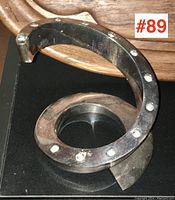 Photo showing metal spiral design of candle stick with dot details and flat base on black surface