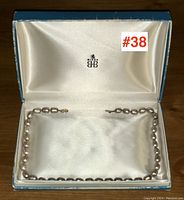 Full view of pearl choker displayed in original presentation box on satin lining